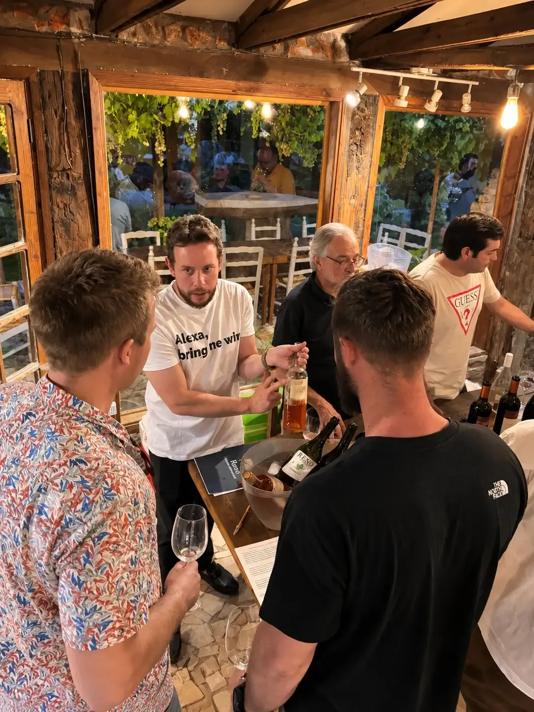 Anfitrión presenta una botella de vino rosado a un grupo durante una degustación