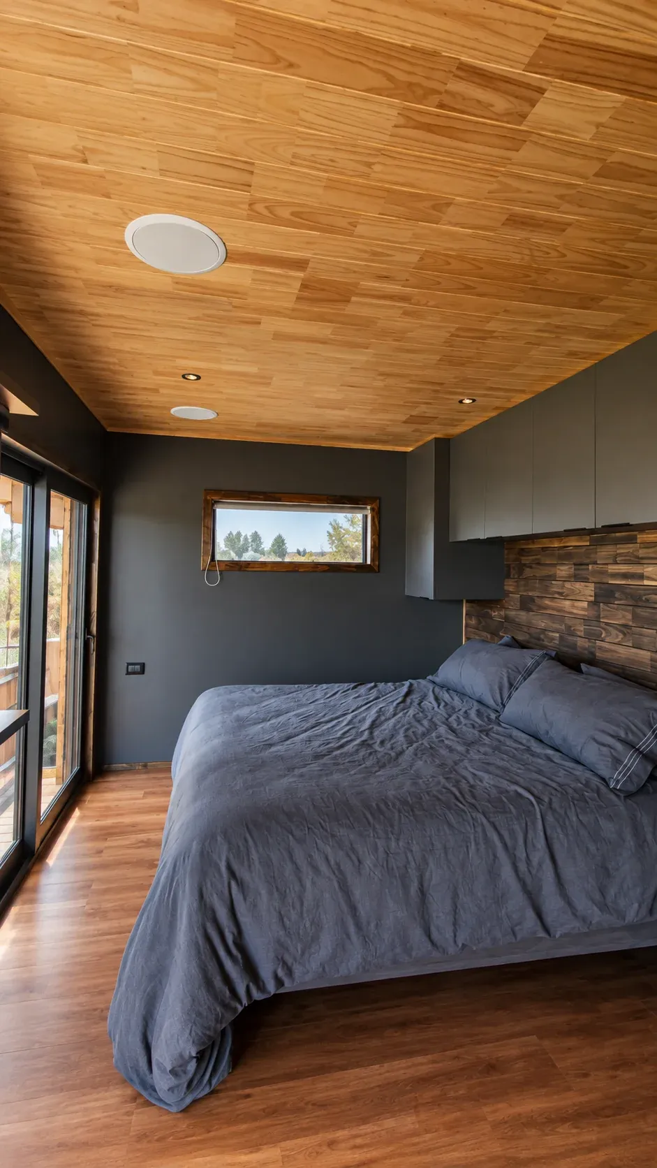 La cama junto a la ventana del Rhenus Wine Lodge, con el viñedo enmarcado al otro lado